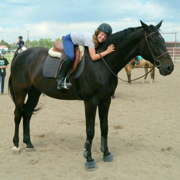 Young rider hugging the horse Frenchie