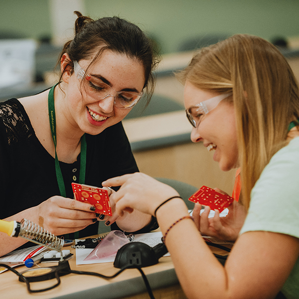 CSU student mentors a high school student over circuit boards