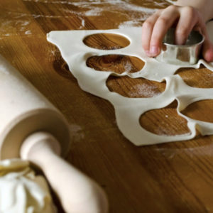 Student using a biscuit cutter to make circles from dough