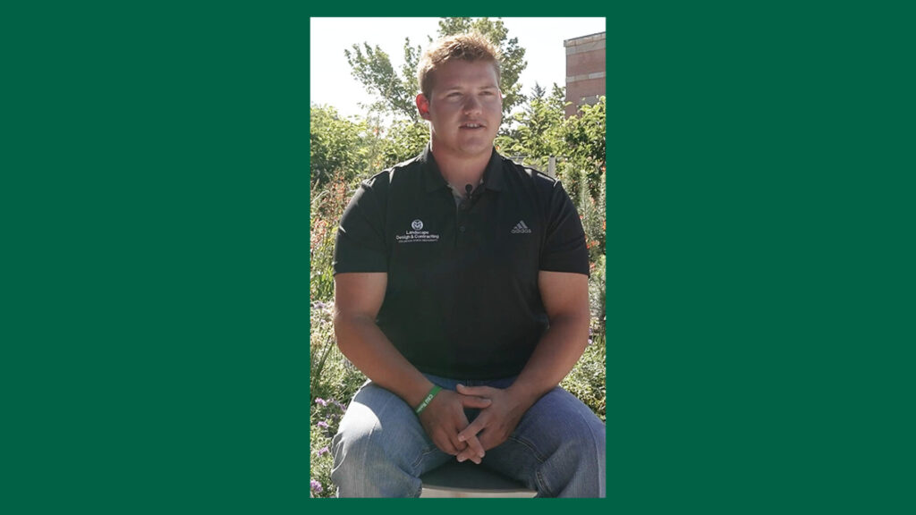 A major in landscape design at CSU sits in front of the rooftop xeriscape garden at the Nutrien building on the Colorado State University campus.